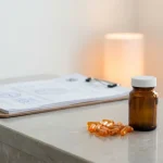 Flacon de médicament et gélules sur un comptoir de pharmacie, dossier officiel en attente
